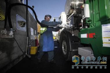 一名工人正在給垃圾車加“氣”