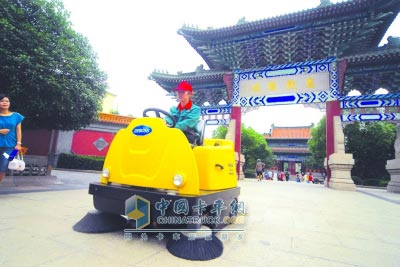 工人們正在操作新款電力清掃車對公園內(nèi)的地面進(jìn)行清潔