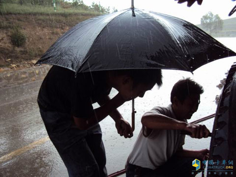 陜汽山西朔州大飛達服務(wù)站維修師傅李澤平為用戶冒雨修車