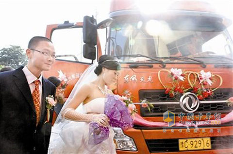 新郎新娘在東風(fēng)天龍的婚車前合影
